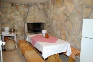 eine Küche mit einem Tisch und einer Steinmauer in der Unterkunft Apartments by the sea Brna, Korcula - 4333 in Brna