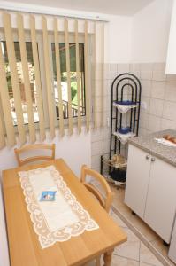 a kitchen with a wooden table and a table and chairs at Apartments by the sea Brna, Korcula - 4333 in Brna