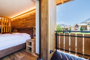 a bedroom with a bed and a balcony at Steinbock B&B - Apartaments in Livigno