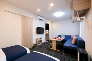 una camera d'albergo con un divano blu e un tavolo di Minn Kasai a Tokyo