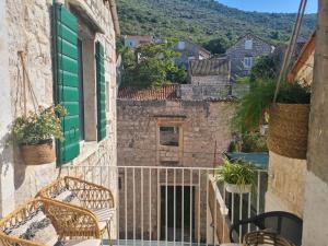 a balcony with chairs and a green door at Apartment Tomazina (seaview,central, heritage) in Vis