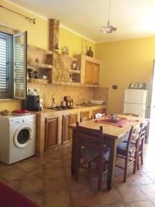 eine Küche mit einem Tisch und einer Waschmaschine in der Unterkunft Villetta Torre Salsa in Siculiana