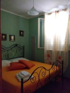ein Schlafzimmer mit einem Bett mit orangefarbenen Kissen und einem Fenster in der Unterkunft Villetta Torre Salsa in Siculiana