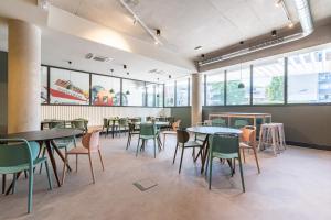 a dining room with tables and chairs and windows at Student Factory Montpellier Sud in Montpellier