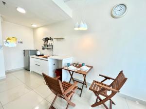 a kitchen with a table and two chairs and a counter at A 1-4 pax Cozy Studio TV Box Pool 100mps Wifi 3 bed Trefoil Setia Alam in Setia Alam