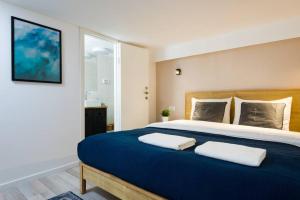 a bedroom with a large blue bed with two white pillows at Musrara #5 in Jerusalem