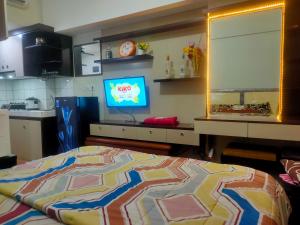 una camera con letto e TV in cucina di The Springlake and View Summarecon Bekasi Studio MDN Furnish and WiFi a Bekasi