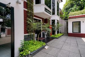 un chat posant sur le sol devant un bâtiment dans l'établissement RedDoorz Premium near RS Pondok Indah La Maison, à Jakarta