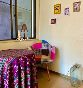 a room with a chair and a table and a window at Guesthouse POPTONE in Hiroshima