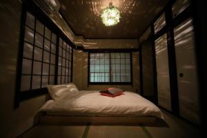 a small bed in a room with two windows at ぷふか亀戸 in Tokyo