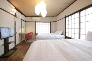 a hotel room with two beds and a tv at ぷふか亀戸 in Tokyo
