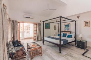 a bedroom with a canopy bed and a living room at Beachfront mansion with pool in Calangute +35 photos