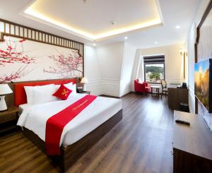 a hotel room with a large bed and a desk at Da Lat Prince Hotel in Da Lat