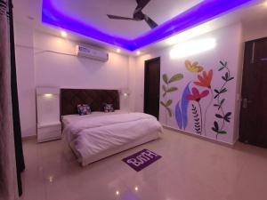 um quarto com uma cama com um tecto roxo em Own Stay em Nova Deli