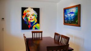 a dining room table with a painting on the wall at Great Views, Ultimate Comfort and Top Location! in Caloundra