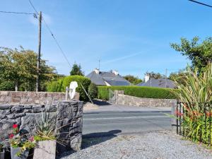 a driveway with a stone fence and a house at Bealadangan Holiday Home 