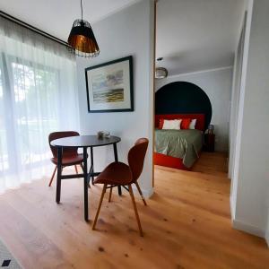 ĶesterciemsにあるKesterciems seaside apartment with terraceのテーブル、椅子、ベッドが備わる客室です。