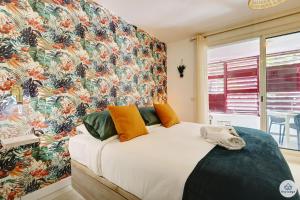 - une chambre avec un grand lit et un mur coloré dans l'établissement Studio classé 2 étoiles - L'Eden - Saint-Denis, à Saint-Denis