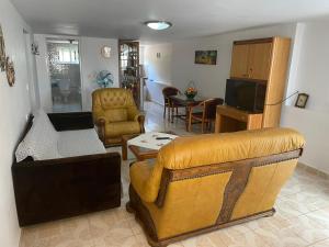 a living room with a couch and a television at Apartamente Gleni in Sarandë
