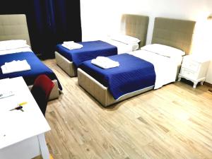 Habitación con 3 camas, mesa y sillas en Nuova fiera camera, en Verona