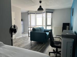 um quarto com um sofá, uma cadeira e uma secretária em Piscine olympique - Premiere conciergerie em Montpellier