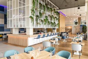 a restaurant with tables and chairs and a bar at Holiday Inn Express Amsterdam - North Riverside by IHG in Amsterdam