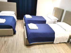 3 camas en una habitación de color azul y blanco en Nuova fiera camera, en Verona