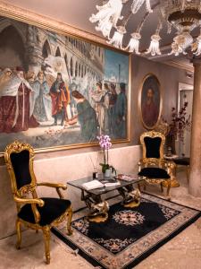 a living room with a painting and two chairs and a table at Egò Boutique Hotel The Silk Road in Venice