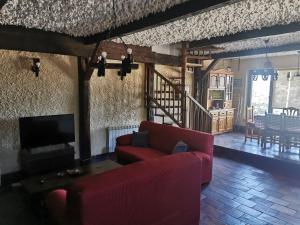 a living room with a red couch and a tv at CASA TEO in Ávila