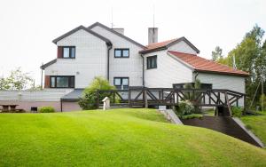 a house with a wooden bridge in front of a yard at Reiumaa Motell in Reiu