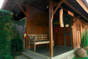 una panchina di legno seduta fuori da una casa di Rumah Tembi a Yogyakarta