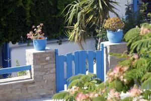a blue fence with two potted plants on it at Stratos Apartments & Studios in Parikia