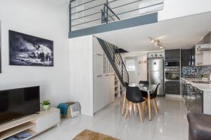 a kitchen and living room with a table and chairs at Sutton Place 57 in Cape Town