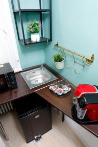 una encimera con fregadero y un aparato rojo en Grand Phillip Cismigiu Park Downtown Bucharest, en Bucarest