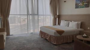 a hotel room with a bed and a window at Grand Tourist Hotel in Muscat