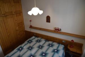 ein kleines Schlafzimmer mit einem Bett und einer Lampe in der Unterkunft Appartamento Alto Cordevole in Colle Santa Lucia