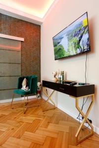 escritorio y silla en una habitación con TV en la pared en Grand Phillip Cismigiu Park Downtown Bucharest, en Bucarest