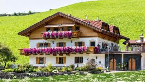 a house with flowers on the side of it at Bergblick App Fichte in Villnoss