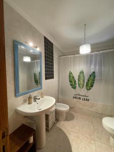 a bathroom with a sink and a toilet and a mirror at Beach house Cala Morlanda in S'Illot
