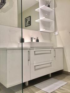 una cocina con armarios blancos y fregadero en Luxury Apartment Tomaso - The View Fuengirola, en Fuengirola