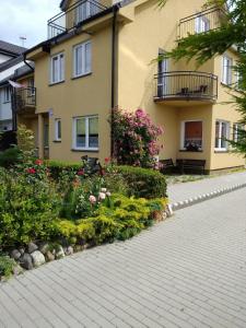 un edificio con flores delante en Baltazar, en Łeba