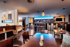 um restaurante com mesas e cadeiras e um bar em Select Hotel Mainz em Mainz