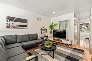 een woonkamer met een bank en een tv bij Snowy Peaks - Queenstown Holiday Apartment in Queenstown