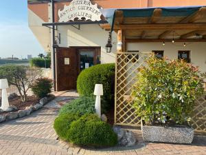 un edificio con una puerta y arbustos delante de él en HOTEL RISTORANTE ANTICO GUERRIERO, en Cadoneghe