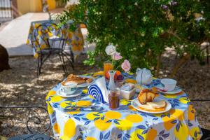 una mesa azul y amarilla con comida. en I Lecci Guesthouse en San Felice Circeo