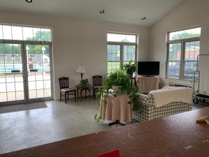 a living room with a couch and chairs and windows at Monticello Inn - Monticello, Indiana in Monticello