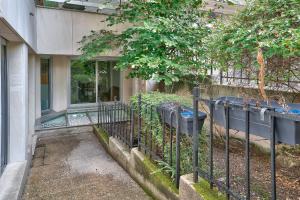 ein Zaun vor einem Haus mit Pflanzen in der Unterkunft Bel appartement idéal pour 4 personnes, 2 chambres in Paris