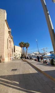 a street next to the water with palm trees at perle rare à la ciotat in La Ciotat