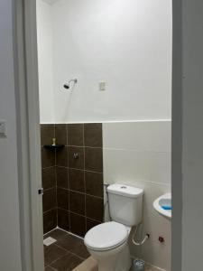 La salle de bains est pourvue de toilettes et d'un lavabo. dans l'établissement OrchidVilla Homestay at Southville Apartment, à Kampong Parit
