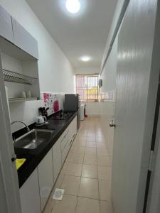 - une cuisine avec un évier et un comptoir dans l'établissement OrchidVilla Homestay at Southville Apartment, à Kampong Parit
